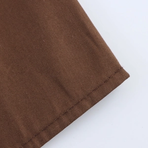 Close-up of brown textured fabric with neat stitching on a high-quality elegant dress