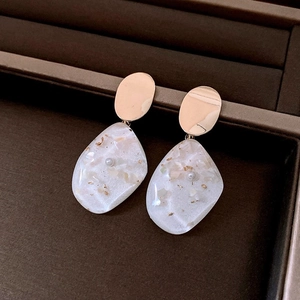 Detailed close-up of vintage resin drop earrings with gold foil and pearls on velvet