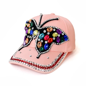 Detail of pink denim baseball cap featuring vibrant rhinestone butterfly embroidery