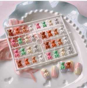 Macro detail of colorful resin 3D bear nail art charms displayed on gradient nails
