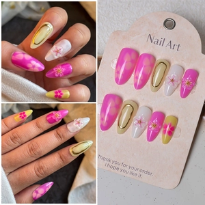 Detail of 3D floral press-on nails with gold stamping and hand-painted almond shape art