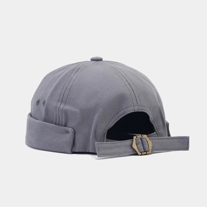 Détail du bonnet docker gris avec boucle métallique réglable et texture en toile
