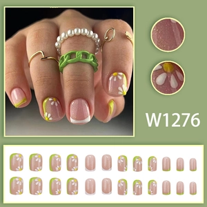 Short green French press-on nails with white daisy patterns and partial side designs