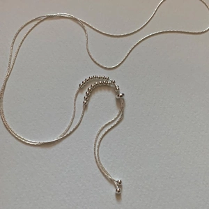 Detail of silver beaded necklace chain with minimalist sliding adjustment beads