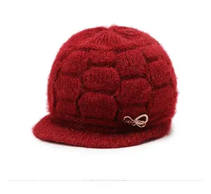 Detail of red knitted winter hat showing side view with sparkling rhinestone butterfly pin