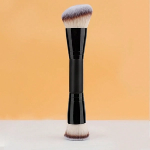 Dual-ended makeup brush detail with slanted and flat bristles on a minimalist background