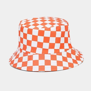 Detailed view of the orange and white checkerboard pattern on the reversible bucket hat