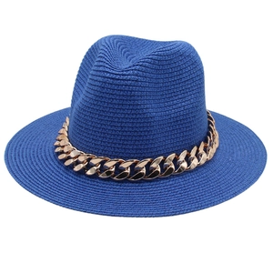 Chapeau Panama en paille bleue avec une grosse chaîne en acrylique dorée décorative.
