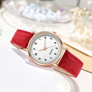 Elegant ladies quartz watch with red suede strap and golden round case on floral background