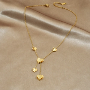 Minimalist Y-shaped gold plated stainless steel necklace with five heart charms on champagne silk