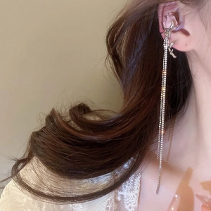 Close-up of sparkling silver star tassel ear cuff with rhinestones on model side view