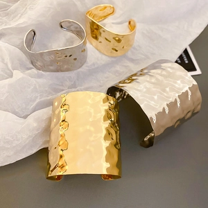 Macro shot of irregular hammered metal textures on gold and silver minimalist bangles