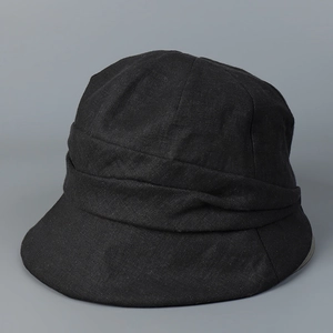 Détail d'un chapeau de soleil en lin noir avec plis texturés et tissu naturel respirant