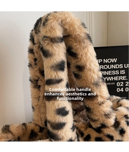 Detail shot of the plush leopard print faux fur handbag featuring a wide comfortable handle