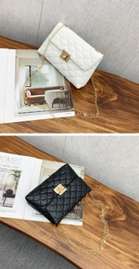 Détail de sacs à main brodés à chaîne en noir et blanc avec accessoires métalliques