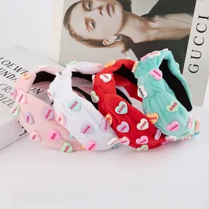 Pink, red, and blue plush knotted headbands with heart charms and XOXO embroidery