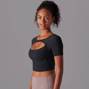 Detail of black sports bra featuring chest cutout and sheer mesh panels for fitness