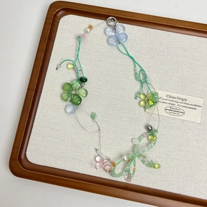 Detail of handcrafted floral beaded necklace with glass crystals and pearls on linen board