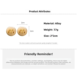 Detail showing 2x2cm round alloy earrings with golden 'm' letter and silver pins