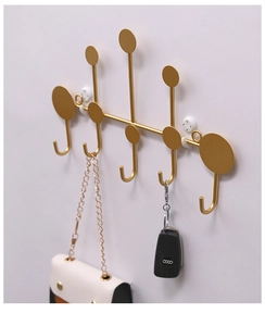 Detailed close-up of golden 5-hook wall rack with bags and keys for load-bearing display