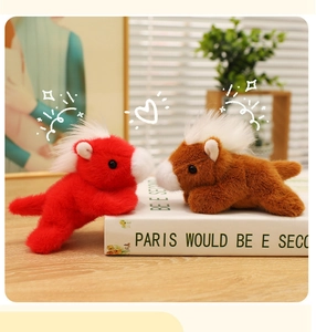 Detail of red and brown plush horse toys with fluffy white manes on a decorative book
