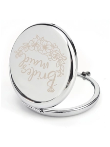 Detailed view of silver bridesmaid makeup mirror with elegant floral engraving and metal finish