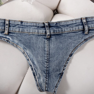 Détail de couture jaune contrastée et texture denim sur un mini short bleu sexy