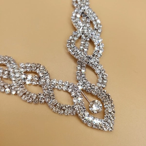 Close-up of bridal silver necklace featuring intricate crystal pavé links and a center round stone
