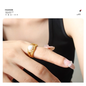 Close-up of 18K gold-plated braided ring with a large freshwater pearl and zircon halo