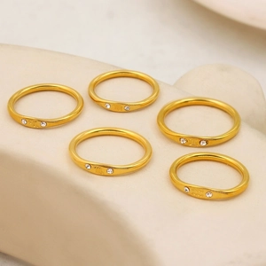 Macro shot of 18K gold stainless steel zodiac rings with small diamonds on stone display