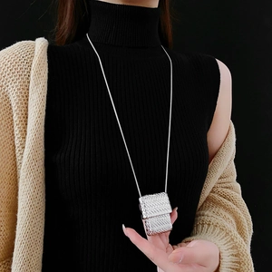 Detail of silver long sweater snake chain with a textured rectangular purse pendant