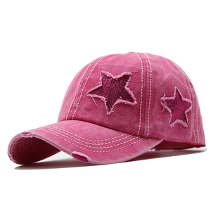 Détail de la casquette rose en coton délavé avec trous usés et étoiles scintillantes