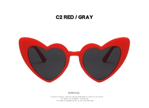 Detail of red heart shaped sunglasses with dark gray lenses and fashion C2 color frame