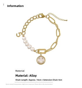 Detail of gold-plated chain bracelet with freshwater pearls and a lucky number 5 charm