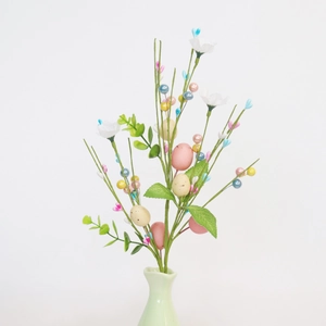 Easter egg branch with macaron colors, white flowers and berries in a green ceramic vase