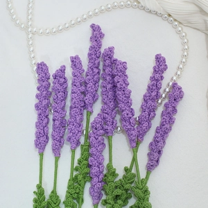 Détail macro de fleurs de lavande au crochet faites main sur tissu blanc décoré