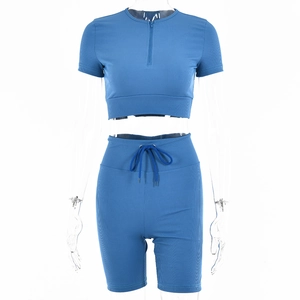 Detail of blue ribbed knit sports set featuring short sleeve half-zip crop top and drawstring shorts