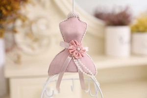 Detail of pink mannequin jewelry stand with lace, silk petals, and pearl decorations