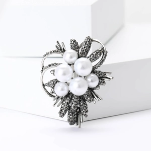 Detailed view of high-grade floral brooch with white pearls and black rhinestones