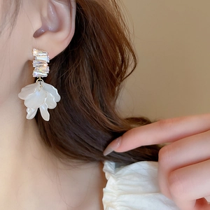Detail view of gold-plated flower tassel earrings with zircons on a model side profile