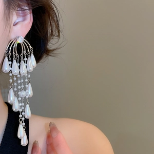 Detail of silver drop earrings with white pearls and sparkling crystal tassels