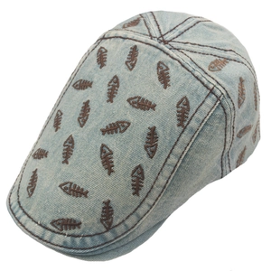 Detail shot of vintage washed denim flat cap with brown fishbone embroidery patterns