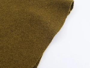 Gros plan sur le tissu en maille vert olive montrant la texture de laine et les détails des fibres