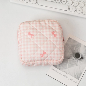 Detailed embroidery of pink bows on quilted plaid fabric of the cosmetic organizer bag