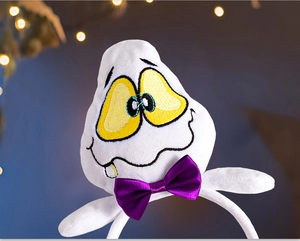Detail of white plush ghost headband with purple bow and yellow embroidered eyes for parties