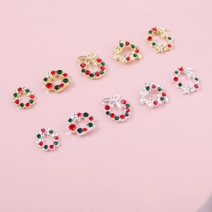 Détail de charmes à ongles couronne de Noël avec strass rouges, verts et petits nœuds