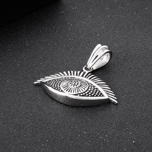 Close-up of vintage steel evil eye turtle pendant with detailed radial engravings