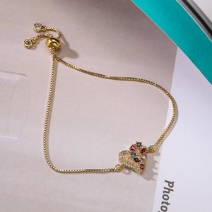 Close-up of heart charm bracelet with colorful zircons and adjustable gold chain