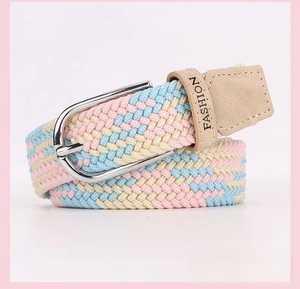 Detail of woven elastic belt in pastel tones with silver D-ring buckle and leather end