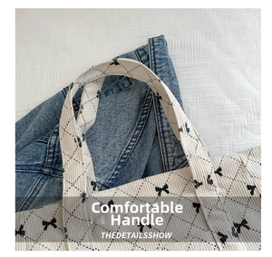 Macro detail of quilted corduroy tote bag showing wide handles and bow pattern